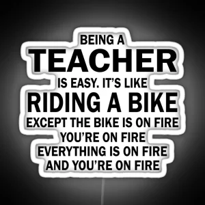 BEING A TEACHER IS EASY IT S LIKE RIDING A BIKE EXCEPT THE BIKE IS ON FIRE YOU RE ON FIRE EVERYTHING IS ON FIRE AND YOU RE ON FIRE RGB Neon Sign