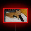 Feline vigilante alert: quirky cat holds a pistol in color.
