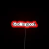 Vibrant Neon Wall Sign Reads 'God Is Good' in Script.