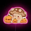 Vibrant neon sign featuring happy mushrooms and colorful pumpkin accents.