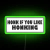 Vibrant neon highway decoration that reads Honk If You Like Honking