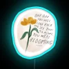 Whimsical glowing reminder of personal growth through vibrant colorful neon signs.