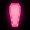 Boldly lit pink neon sign shaped like an open coffin.