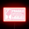 Vibrant pink fragile warning sign with colorful RGB neon lighting accents