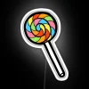 Vibrant rainbow lollipop patterned neon sign in colorful RGB glow.