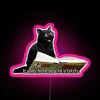 Neon-lit RGB sign with iconic witch design and glowing accents.