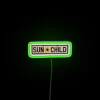Vibrant neon sign featuring a happy child's face symbolizing warmth.
