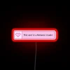 Pastel pink neon sign featuring heart pixel art for readers.