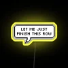 RGB neon sign displaying "Let Me Just Finish This Row" in vibrant yellow.