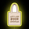 cute beige and brown tote bag with 'let's go book shopping' rgb neon sign in yellow