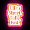 neon sign with rgb pink glow reading 'life is short' minimalist design