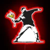 Banksy's iconic love-themed graffiti featuring a flower thrower with an RGB neon red sign.