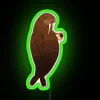 A manatee under a vibrant neon sign promoting cold brew coffee with RGB lighting effects.