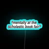 Neon sign reading 'Mentally' at a book fair in blue.