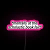 vibrant neon pink sign reading 'Mentally at the Book Fair' – perfect for promoting literature events.