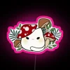 A colorful cat surrounded by a neon mushroom sign in vibrant RGB pink tones.