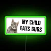 A child eating bugs in an RGB neon green sign.