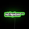 A neon sign displaying 'Not all math puns are terrible, just sum' with RGB LED lights and a neon green background.