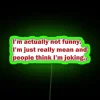 A vibrant neon sign reading 'not joking – i'm mean' with RGB lighting in green.