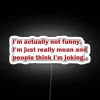 RGB neon sign displaying 'Not joking—i'm mean' on a white background