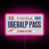 Neon pink LED sign at Oberalp Pass in Switzerland, lighting up the motorcycle route with vibrant RGB neon lights.