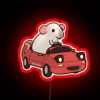 A rat on a Mazda Miata with an RGB neon sign in vibrant red.