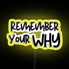 motivational quote about remembering your why in a vibrant neon sign with yellow lighting