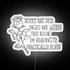 neon sign displaying roses are red pages are worn book practically porn