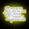 rgb neon sign saying roses are red pages are worn book i'm reading is practically porn.