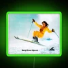 Skiing girl standing in front of a vibrant, neon-lit green sign
