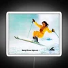 Neon ski girl standing in front of a colorful background.