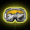 Neon sign featuring colorful ski goggles and snowboard accessories in a modern, urban background.