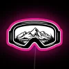 Neon pink ski goggles against a colorful travel-inspired design background.