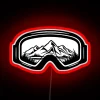 Ski goggles with neon details against a colorful travel-inspired background.