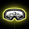 Colorful ski goggles with neon accents against a bright yellow background, blending travel, art, and design elements.