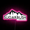 Skiing and snowboarding at Sugarbush Resort in Warren, Vermont, with a vibrant neon pink mountain sign.