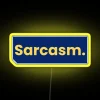 Neon sign reading "Slay with Sarcasm" in bold, yellow font.