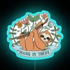 Sloth hanging from neon sign with "Hang in there" phrase.