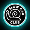 Neon sign reading 'Slow Car Club' on a dark blue background.