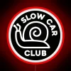 Neon sign with slow car club logo on a black background.