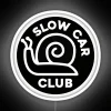 Neon sign with 'Slow Car Club' logo on a black background.