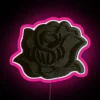 Close-up of a small black rose-shaped LED neon sign with pink accents.