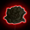 Small black rose LED sign with red neon accents on a dark background.