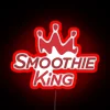 Neon sign advertising Smoothie King cafe in bright red color.