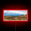 A snowy mountain landscape with vibrant neon sign reflections in a red-toned HDR effect.