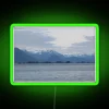 Mountain landscape with snow-covered peaks, illuminated by a vibrant neon sign.