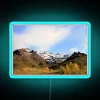 Dramatic snowy mountain peaks of Denali illuminated by neon lights.