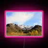 Mountain landscape with snowy peaks under neon lights.
