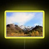Mountain landscape with snowy peaks of Denali illuminated by neon lights in vibrant yellow hues.