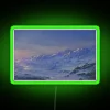 Neon sign reflecting off snowy mountainside with vibrant green color scheme.